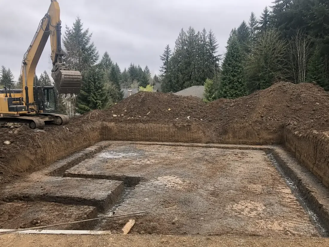 Foundation excavation with squared footing trenches and an excavator in Beaverton, OR
